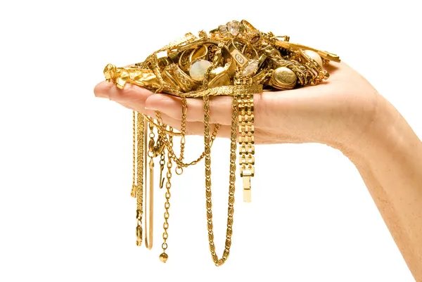 A hand holding a pile of gold jewelry and chains