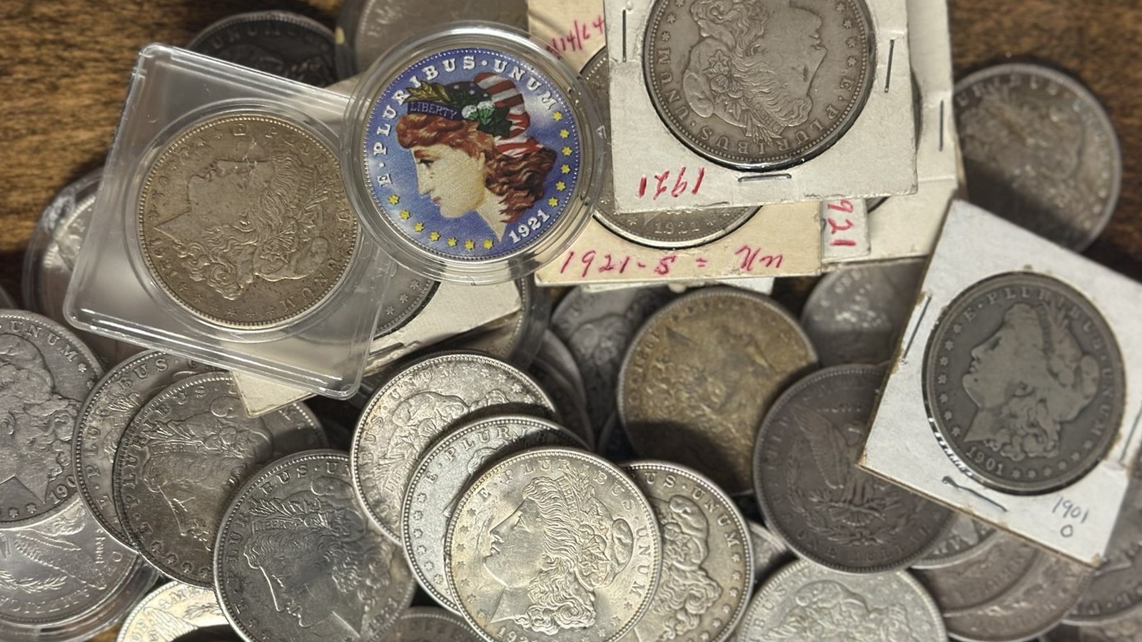 A collection of Morgan silver dollars, some labeled and dated